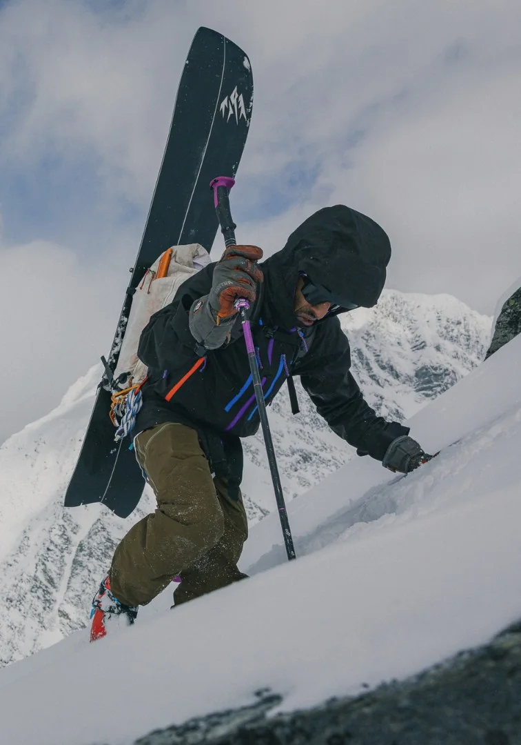 Alpinist climbing a snow slope at sunrise