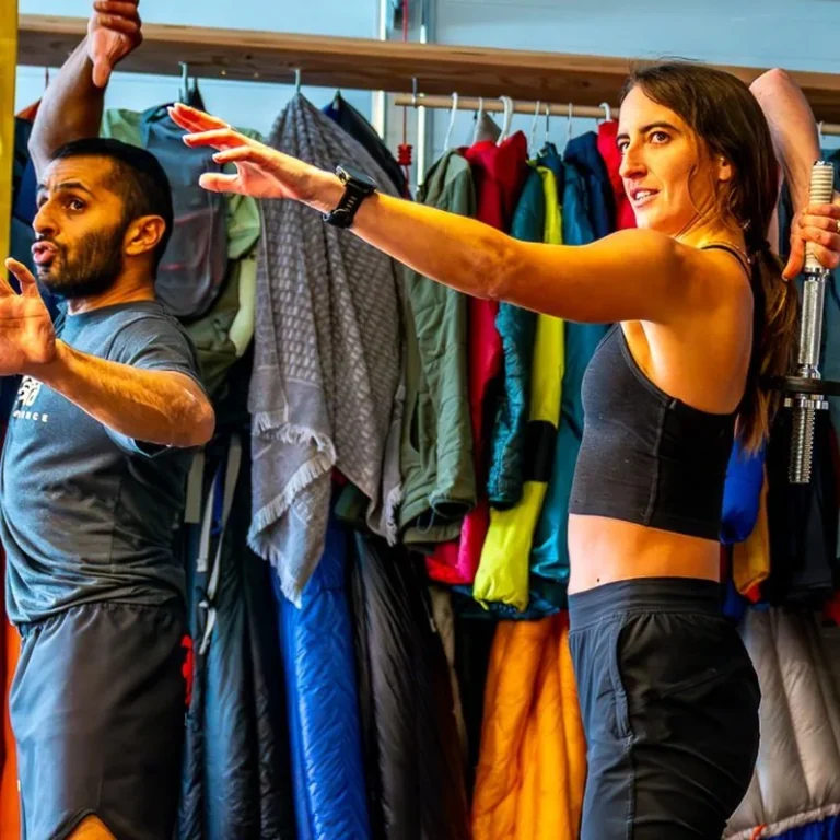 Two athletes performing a shoulder mobility drill in the Samsara garage gym