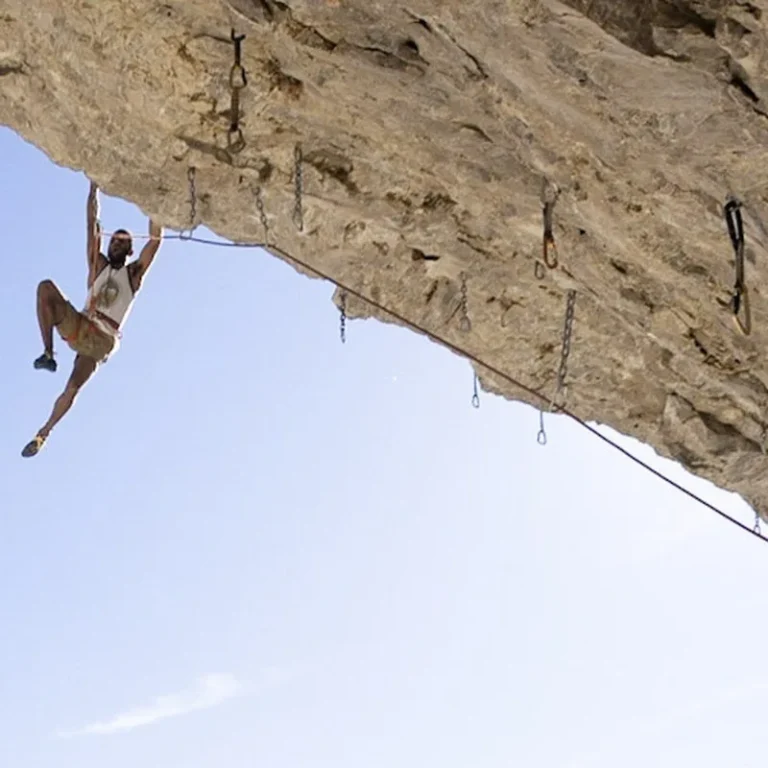 Climber hanging from a steep limestone roof on a sport route