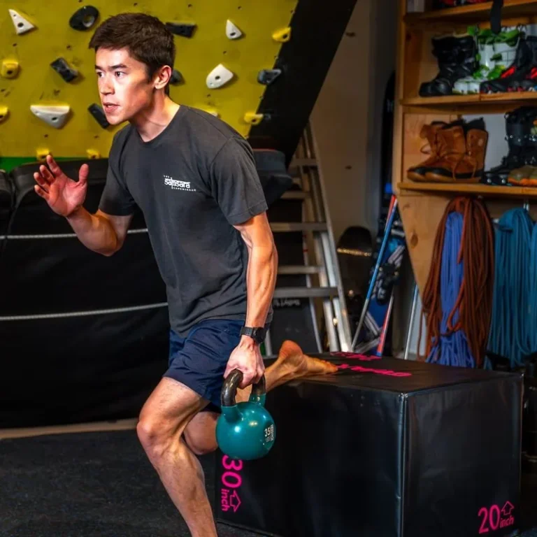 Athlete performing a single-leg step-up holding a kettlebell